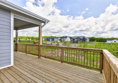 Spacious wooden deck overlooking a suburban neighborhood under a cloudy sky.