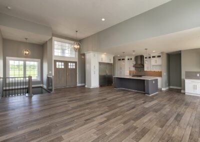 Modern open-plan kitchen and living area with wooden flooring and neutral color scheme.